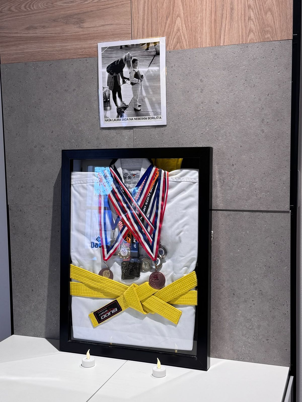 Uokvireni dobok sa žutim pojasom i medaljama