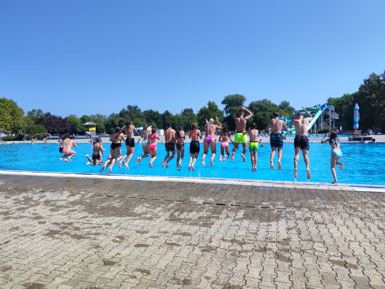 Članovi kluba skaču u bazen na ljetnom kampu